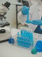 Health care researchers working in life science laboratory. Young female research scientist and senior male supervisor preparing and analyzing microscope slides in research lab. photo