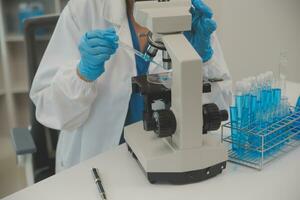 Health care researchers working in life science laboratory. Young female research scientist and senior male supervisor preparing and analyzing microscope slides in research lab. photo