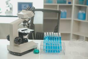 Health care researchers working in life science laboratory. Young female research scientist and senior male supervisor preparing and analyzing microscope slides in research lab. photo