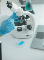Health care researchers working in life science laboratory. Young female research scientist and senior male supervisor preparing and analyzing microscope slides in research lab. photo