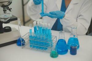 Health care researchers working in life science laboratory. Young female research scientist and senior male supervisor preparing and analyzing microscope slides in research lab. photo