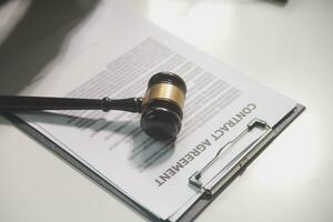 Business and lawyers discussing contract papers with brass scale on desk in office. Law, legal services, advice, justice and law concept picture with film grain effect photo