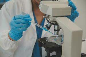 Health care researchers working in life science laboratory. Young female research scientist and senior male supervisor preparing and analyzing microscope slides in research lab. photo