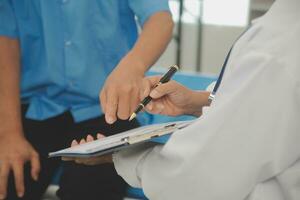 Close up of Female Doctor using stethoscope putting beat heart diagnose with patient in examination room at a hospital, check-up body, Medical and Health Care Concept. photo