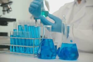 investigadores de atención médica que trabajan en el laboratorio de ciencias de la vida. joven científica investigadora y supervisora masculina senior preparando y analizando portaobjetos de microscopio en el laboratorio de investigación. foto