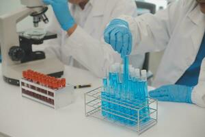 Health care researchers working in life science laboratory. Young female research scientist and senior male supervisor preparing and analyzing microscope slides in research lab. photo