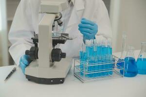 investigadores de atención médica que trabajan en el laboratorio de ciencias de la vida. joven científica investigadora y supervisora masculina senior preparando y analizando portaobjetos de microscopio en el laboratorio de investigación. foto