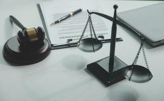 Business and lawyers discussing contract papers with brass scale on desk in office. Law, legal services, advice, justice and law concept picture with film grain effect photo