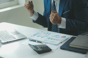 Close up Business woman using calculator and laptop for do math finance on wooden desk, tax, accounting, statistics and analytical research concept photo