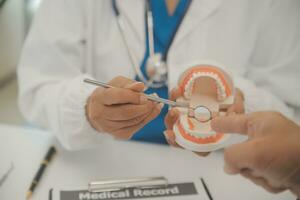 los dentistas están discutiendo problemas dentales al informar la imagen de rayos X en la pantalla del portátil a los pacientes. foto