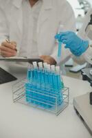 Health care researchers working in life science laboratory. Young female research scientist and senior male supervisor preparing and analyzing microscope slides in research lab. photo