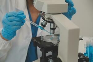 Health care researchers working in life science laboratory. Young female research scientist and senior male supervisor preparing and analyzing microscope slides in research lab. photo