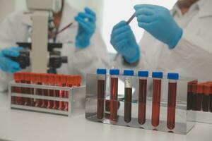 investigadores de atención médica que trabajan en el laboratorio de ciencias de la vida. joven científica investigadora y supervisora masculina senior preparando y analizando portaobjetos de microscopio en el laboratorio de investigación. foto