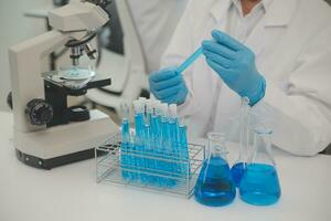Health care researchers working in life science laboratory. Young female research scientist and senior male supervisor preparing and analyzing microscope slides in research lab. photo