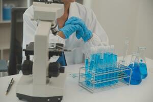 Health care researchers working in life science laboratory. Young female research scientist and senior male supervisor preparing and analyzing microscope slides in research lab. photo