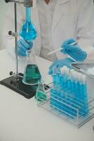 Health care researchers working in life science laboratory. Young female research scientist and senior male supervisor preparing and analyzing microscope slides in research lab. photo