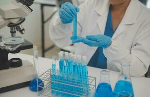Health care researchers working in life science laboratory. Young female research scientist and senior male supervisor preparing and analyzing microscope slides in research lab. photo