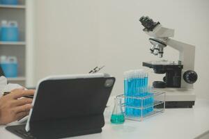 investigadores de atención médica que trabajan en el laboratorio de ciencias de la vida. joven científica investigadora y supervisora masculina senior preparando y analizando portaobjetos de microscopio en el laboratorio de investigación. foto