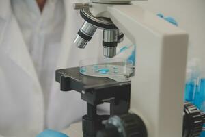 Health care researchers working in life science laboratory. Young female research scientist and senior male supervisor preparing and analyzing microscope slides in research lab. photo