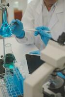 Health care researchers working in life science laboratory. Young female research scientist and senior male supervisor preparing and analyzing microscope slides in research lab. photo
