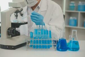 Health care researchers working in life science laboratory. Young female research scientist and senior male supervisor preparing and analyzing microscope slides in research lab. photo