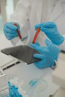 investigadores de atención médica que trabajan en el laboratorio de ciencias de la vida. joven científica investigadora y supervisora masculina senior preparando y analizando portaobjetos de microscopio en el laboratorio de investigación. foto