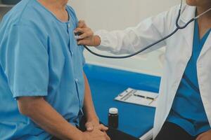 Close up of Female Doctor using stethoscope putting beat heart diagnose with patient in examination room at a hospital, check-up body, Medical and Health Care Concept. photo