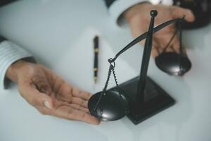 Business and lawyers discussing contract papers with brass scale on desk in office. Law, legal services, advice, justice and law concept picture with film grain effect photo