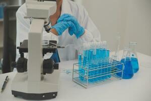 Health care researchers working in life science laboratory. Young female research scientist and senior male supervisor preparing and analyzing microscope slides in research lab. photo