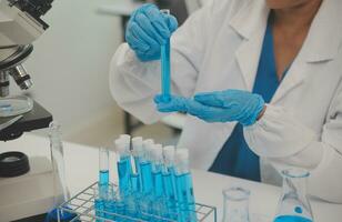 Health care researchers working in life science laboratory. Young female research scientist and senior male supervisor preparing and analyzing microscope slides in research lab. photo