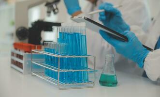 Health care researchers working in life science laboratory. Young female research scientist and senior male supervisor preparing and analyzing microscope slides in research lab. photo