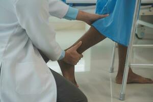 young asian physical therapist working with senior woman on walking with a walker photo