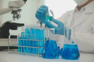 investigadores de atención médica que trabajan en el laboratorio de ciencias de la vida. joven científica investigadora y supervisora masculina senior preparando y analizando portaobjetos de microscopio en el laboratorio de investigación. foto