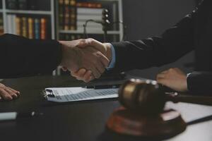 Businessman shaking hands to seal a deal with his partner lawyers or attorneys discussing a contract agreement photo