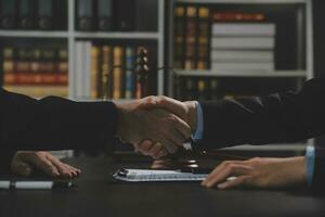 Businessman shaking hands to seal a deal with his partner lawyers or attorneys discussing a contract agreement photo