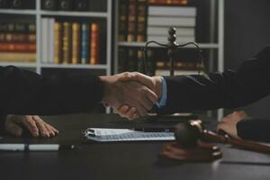 Businessman shaking hands to seal a deal with his partner lawyers or attorneys discussing a contract agreement photo