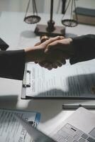 Businessman shaking hands to seal a deal with his partner lawyers or attorneys discussing a contract agreement photo