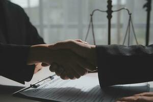 Businessman shaking hands to seal a deal with his partner lawyers or attorneys discussing a contract agreement photo