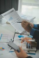 Financial analysts analyze business financial reports on a digital tablet planning investment project during a discussion at a meeting of corporate showing the results of their successful teamwork. photo