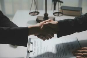 Businessman shaking hands to seal a deal with his partner lawyers or attorneys discussing a contract agreement photo