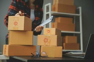 Business woman start up small business entrepreneur SME success .freelance woman working at home with Online Parcel delivery. SME and packaging deliveryconcept photo