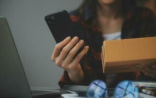 Business woman start up small business entrepreneur SME success .freelance woman working at home with Online Parcel delivery. SME and packaging deliveryconcept photo