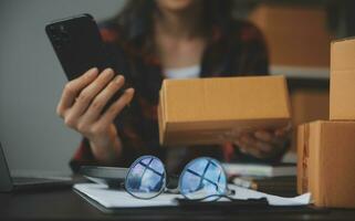 mujer de negocios puesta en marcha empresaria de pequeña empresa sme éxito. mujer independiente que trabaja en casa con entrega de paquetes en línea. concepto de entrega de pymes y embalajes foto