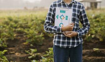 agricultor utilizar el núcleo datos red en el Internet desde el móvil a validar, prueba, y Seleccione el nuevo cosecha método. joven agricultores y tabaco agricultura foto