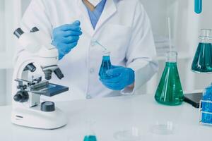 Young scientists conducting research investigations in a medical laboratory, a researcher in the foreground is using a microscope photo