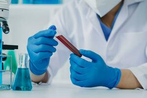Young scientists conducting research investigations in a medical laboratory, a researcher in the foreground is using a microscope photo