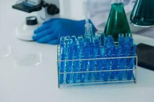 Young scientists conducting research investigations in a medical laboratory, a researcher in the foreground is using a microscope photo