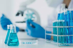 Young scientists conducting research investigations in a medical laboratory, a researcher in the foreground is using a microscope photo