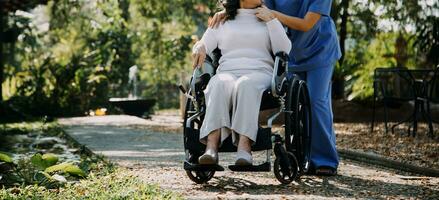 Asian young woman nurse at nursing home take care disabled senior man. Caregiver doctor serve physical therapy for older elderly patient to exercise and practice walking on walker or cane at backyard. photo