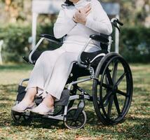 Asian young woman nurse at nursing home take care disabled senior man. Caregiver doctor serve physical therapy for older elderly patient to exercise and practice walking on walker or cane at backyard. photo